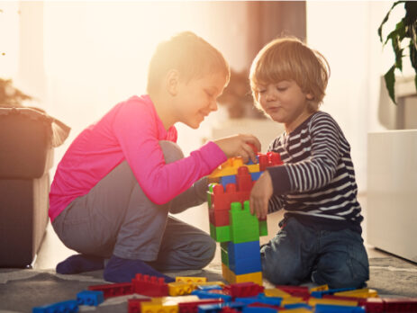 two young boys playing with building blocks