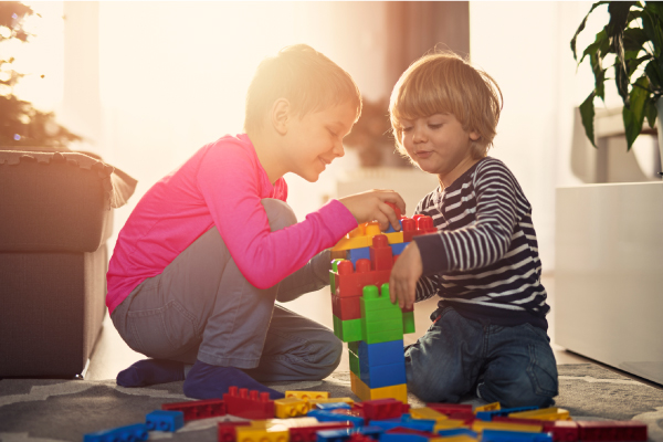 two young boys playing with building blocks