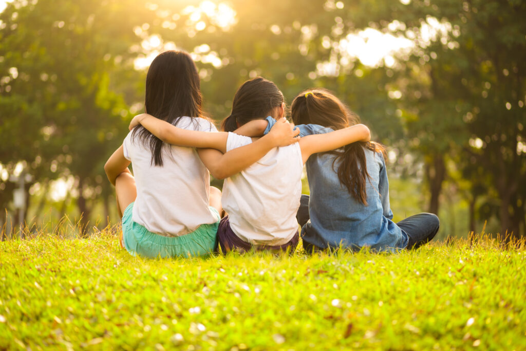 Three young girls sitting on the grass