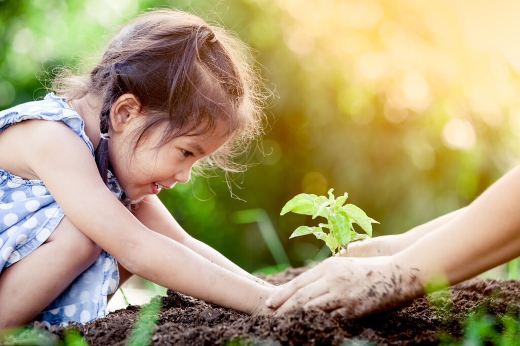 A young girl planting in the garden as she learns about the importance of sustainability