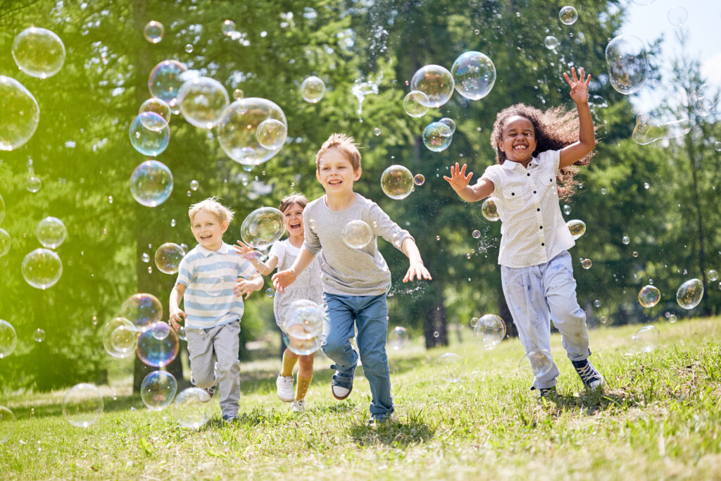 Children running and playing with bubbles, a good example of unstructured play