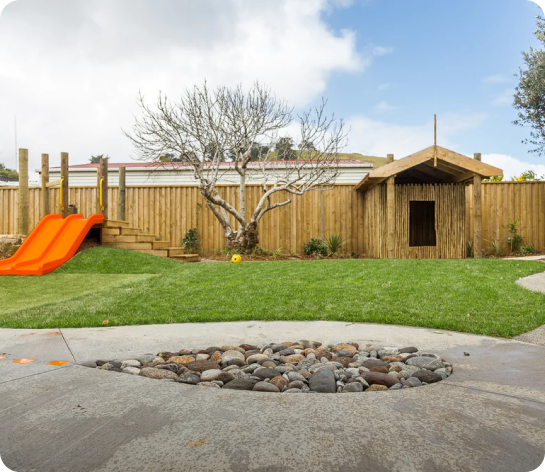 Spotted Frog yard with orange slide in the background